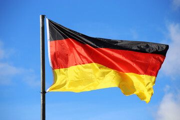 Deutsche Nationalfahne vor blauem Himmel