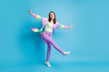Fototapeta na wymiar Full length photo of sweet funny lady wear casual colorful outfit dancing arms hands sides standing one leg isolated blue color background