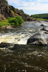 Large boulders are in the mountain river