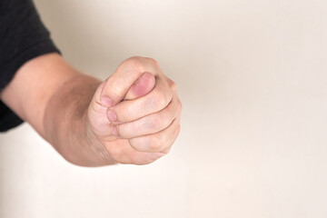A man hand clenched into a fist shows a fig
