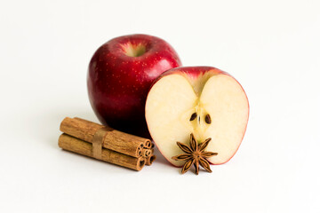 Apple with cinnamon and star anise on a white background.