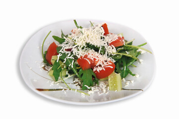Fresh vegetable salad with tomatoes, cucumbers and arugula on a plate isolated on a white background.