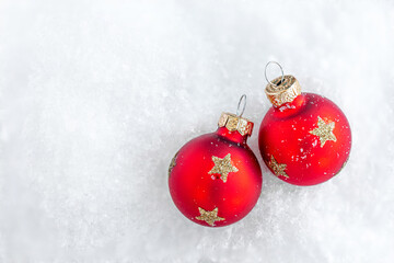 Christmas ornaments on snow with copy space. Glossy red balls top view. .