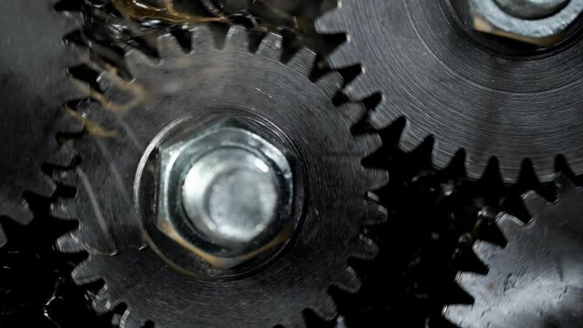 Super slow motion of rotating engine steel wheels with oil splashes. Filmed on high speed cinema camera, 1000 fps.