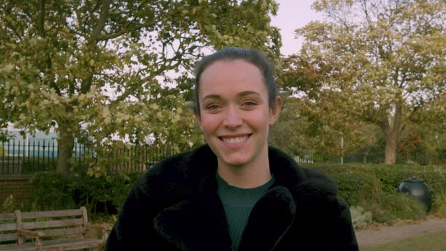 Female smiling at camera in the day in a park