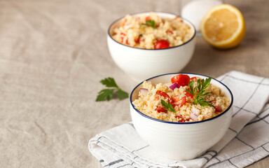 Tabouleh is an Arabic vegetarian salad made with couscous, tomatoes, parsley, onion and lemon juice. Copy space.
