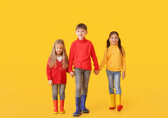 Fototapeta premium Cute little children in autumn clothes on color background