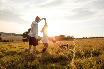 happy young couple at sunset in the field