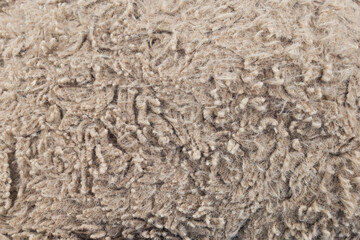 A closeup of the texture of woolen threads that have become woven and stuck together from old age. Lumps, balls of wool and tangled fibers