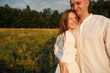 happy young couple at sunset in the field