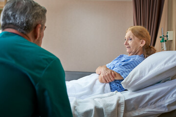 Obraz premium Doctor is talking with old lady patient sit on bed in hospital healthcare