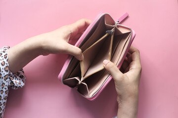  women hand open an empty wallet on pink background 
