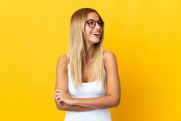 Young blonde woman isolated on yellow background happy and smiling