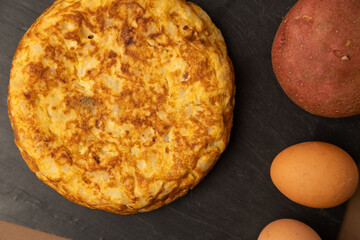 omelette with potatoes on brown background