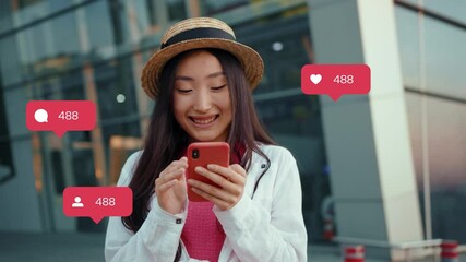 Shooting of young smiling female Asian lifestyle blogger using social network after trip in Europe. Charming young positive woman looking around, reading news on internet. Increase in likes and