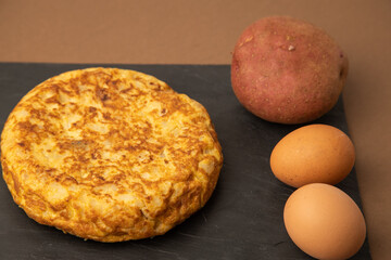 omelette with potatoes on brown background