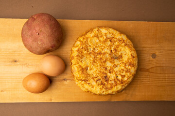 omelette with potatoes on brown background