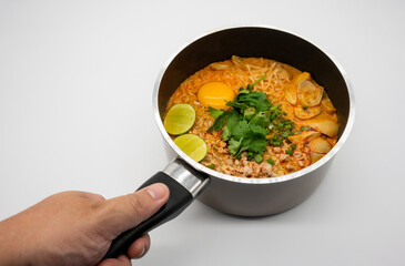 Pork spicy 'Tom Yum' with instant noodle soup in hot pot isolated on white