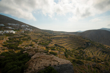 Fototapeta na wymiar View over terraced fields on a slopes near Folegandros town at Folegandros island, Greece