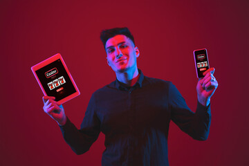 Man holding smartphone, tablet its screen with mobile app for online casino lottery. Male hands...