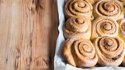 Freshly baked cinnamon buns on parchment paper. Top view, cpyspace. Sweet Homemade Pastry christmas baking. Close-up. Kanelbule - swedish dessert.