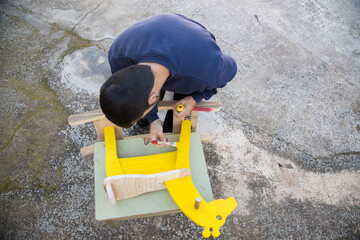 man painting homemade giraffe-shaped rocking horse