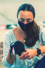 woman wearing face protective medical mask for protection from virus disease in shoes store during...