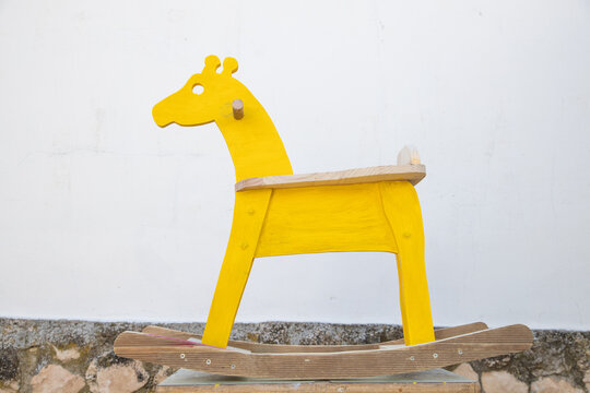 Man Painting Homemade Giraffe-shaped Rocking Horse