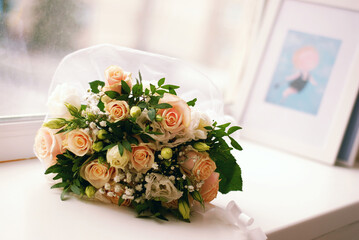 Bridal bouquet of beautiful roses on a white windowsill