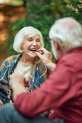 Senior man holding grapes and offering it to his wife