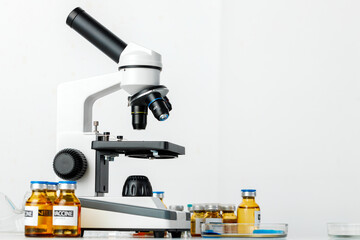 Vaccine bottles and microscope on table in a scientific lab