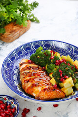 chicken salad with broccoli and ingredients on table. salad with meat, mango and pomegranate closeup