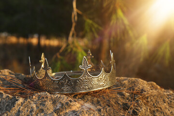 mysterious and magical photo of silver king crown in the England woods over stone. Medieval period...