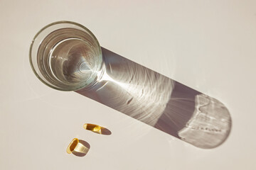 Glass of water and capsules with omega3