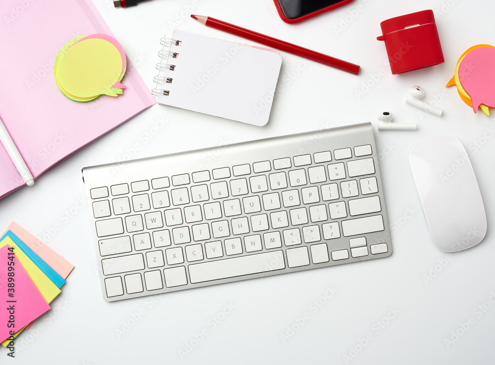 Poster white wireless keyboard, computer mouse and paper notebook