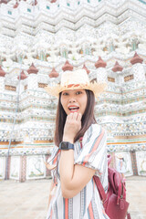 Asian girl tourist smiling while visiting Wat Arun or Temple of Dawn backpacker women