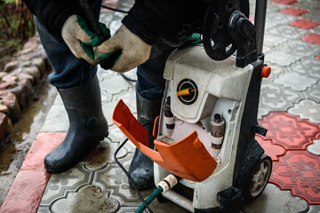 Cleaning paving slab using high pressure power washer.