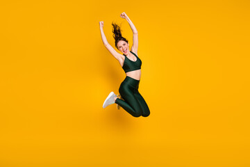 Full length photo of sportive lady jumping high up person raise fists wear sports suit shoes...