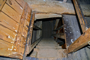 View down a steep old wooden staircase in the roof of the Saint Mary church of Barth, GErmany