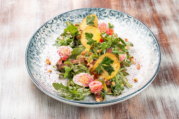 Duck breast salad with potato chips and fresh vegetables. On a decorative plate