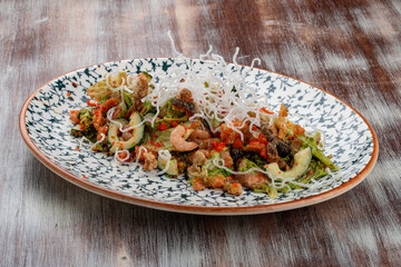 Salad with fried salmon belly, flying fish roe and  lettuce. On a decorative plate