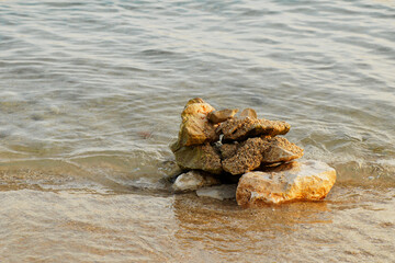 close up view of a pile of stones surrounded by water