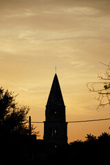 view of an silhouette church tower against a sunset sky