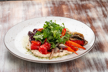 Grilled vegetables on a hummus cushion. Eggplant, pepper, tomato, zucchini, garlic.
