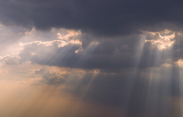 The sun's rays passing through the clouds and shining form an interesting light pattern against the...
