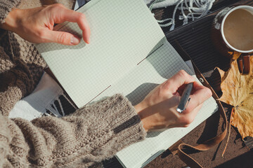 Autumn picnic: girl knitted sweater writes down her sheet todo list diary.