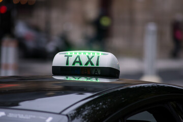 Closeup of taxi sign on the roof of car parked in the street