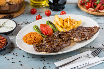 Grilled steak on wooden table. with bulgur pilaf, french frie…