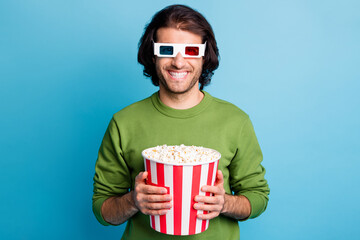 Photo of cheerful guy hold popcorn paper box toothy smile wear 3d glasses green sweater isolated...