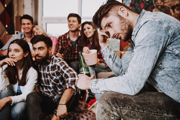 Man with a bottle of beer sits and misses.